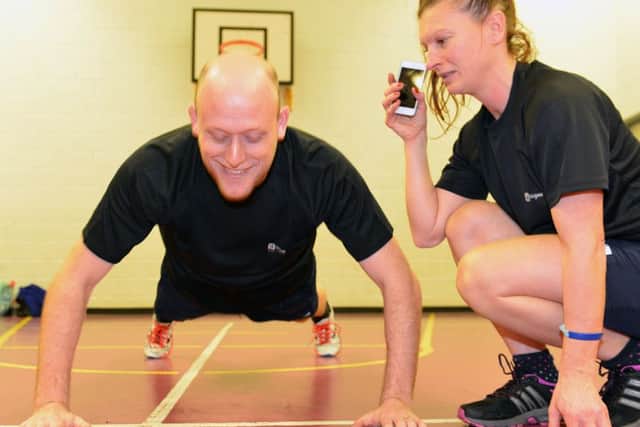 Stranton Academy Headteacher Neil Nottingham starts his press up work under the watchful eye of fitness instructor Roz Charlton as he and his staff become fitter.