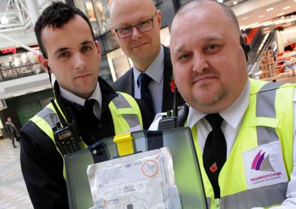 Middleton Grange Shopping Centre security staff Adam Goodwin, left, and Ray Hughes, right, with centre manager Mark Rycraft, with a defibrillator