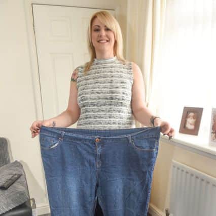 Helen Moss, who has lost more than 6st, with a pair of her old jeans.