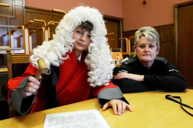 PC Val Matrey (youth offender service) looks on as English Martyrs School pupil Dylan McKimmie plays the Judge . Picture by FRANK REID