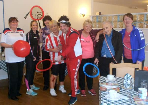 Staff and residents posing in sports wear.