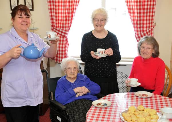 Activities Co-ordinator Debbie Wilkes (left) pours tea for (left to right) resident Mary Gray 100 her daughter Mary Crosby and fellow resident Ann Jenkinson (76) in the Tea Room at Queens Meadow Care Home. Picture by FRANK REID