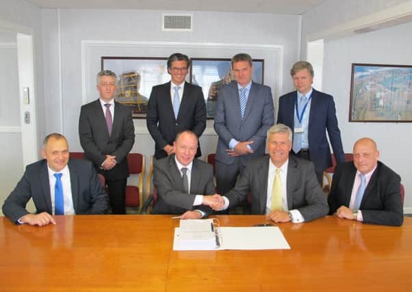 Maersk Oils Culzean project director Martin Urquhart, centre left and Heerema chief executive Koos-Jan van Brouwershaven shake on the platform contract watched by fellow executives.
