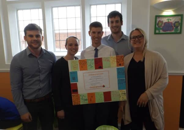 The apprentices who helped give Changing Futures a makeover are presented with a certificate.