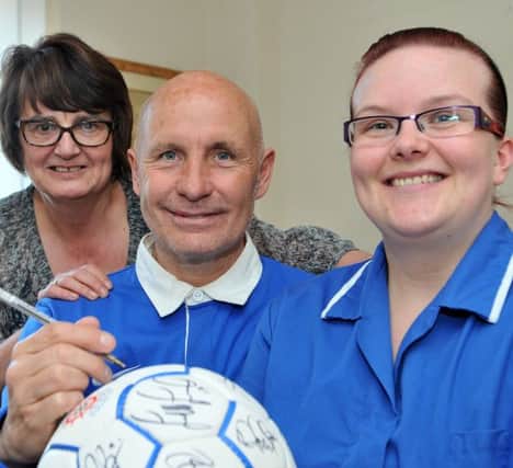Former Hartlepool United player Brian Honour signs a ball for Hartlepool and District Hospice staff Janice Forbes (left) and Cheryl Dignen