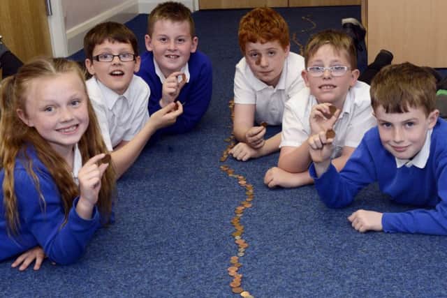 Darci Abbey, James Holland, Callum Smiles, Ben Curry, Reece Hall and Shaun Dennis with the trail of coins for UNICEF at Eskdale Academy