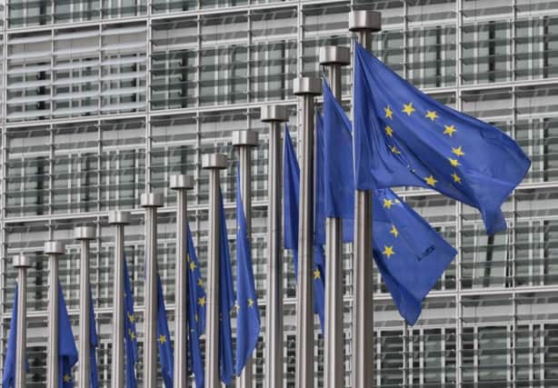 EU flags fly at the European Commission headquarters in Brussels (AP Photo/Yves Logghe, File)