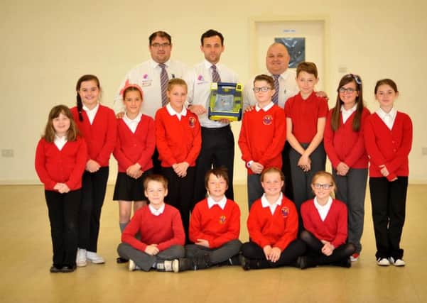 Middleton Grange security officers, back, from left, Paul Foster, Adam Goodwin and Ray Hughes, make the presentation to Blackhall Colliery Primary School on behalf of Defibs for Hartlepool.