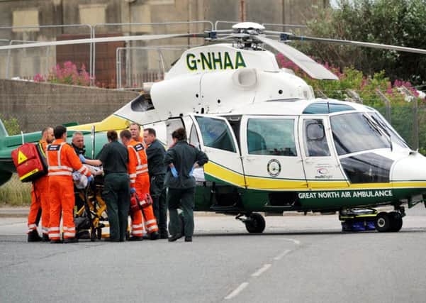 Paramedics place the casualty onto the air ambulance that had landed earlier in Middleton Road.
