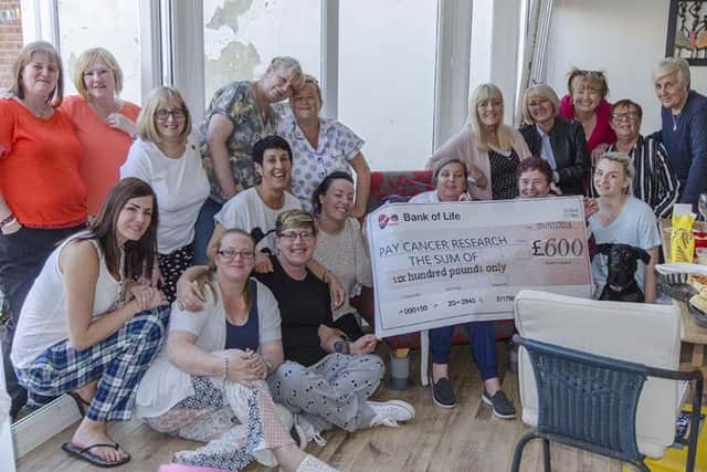 Linda with friends and the cheque for Â£60 raised for Cancer Research.