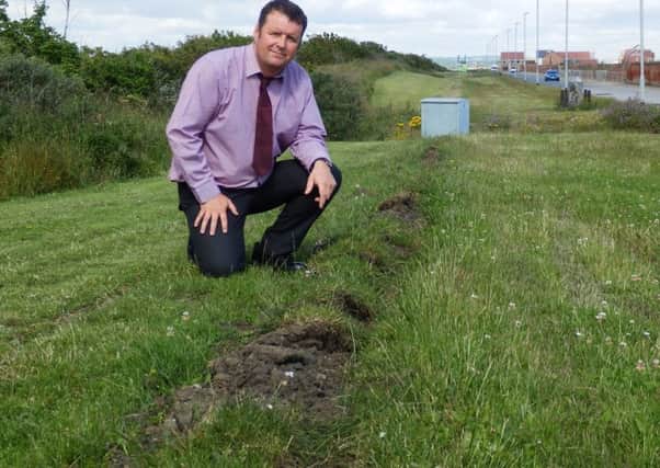 Public Lighting Officer Rob Daley shows where the cable was dragged out of the ground, with the damaged control box in the background.