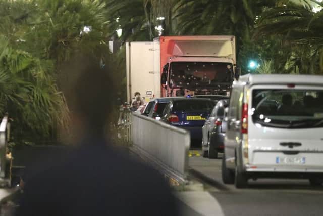 The lorry, its windscreen riddled with bullet holes, is guarded by police (AP)