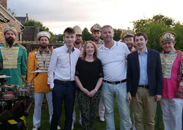 Standing with the band are Eliot, front left, with mum Alison, dad Andrew, and Adam, front right.