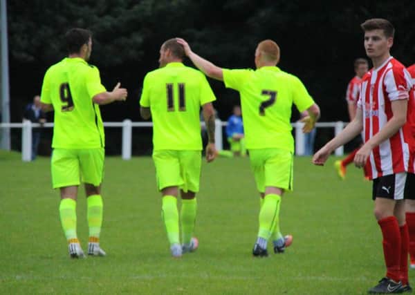 Padraig Amond (left) and Michael Woods (right) congratulate Lewis Alessandra on his first goal. Picture: HUFC