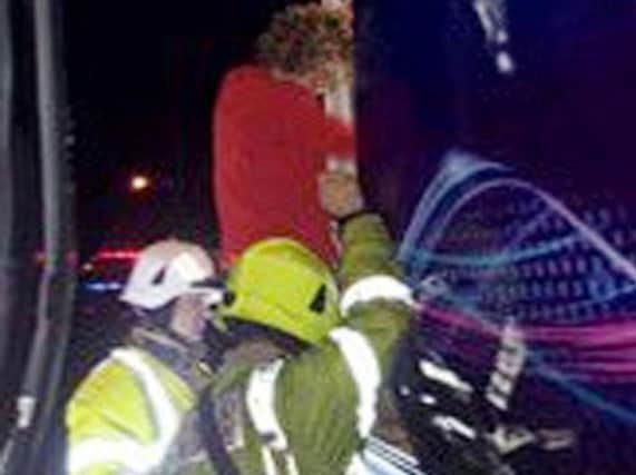 Firefighters help a passenger from the stricken train