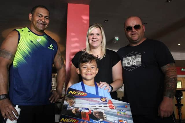 Michael Day, right, hands over an extra birthday surprise to Lewin with dad Suli and mum Lynsey looking on.