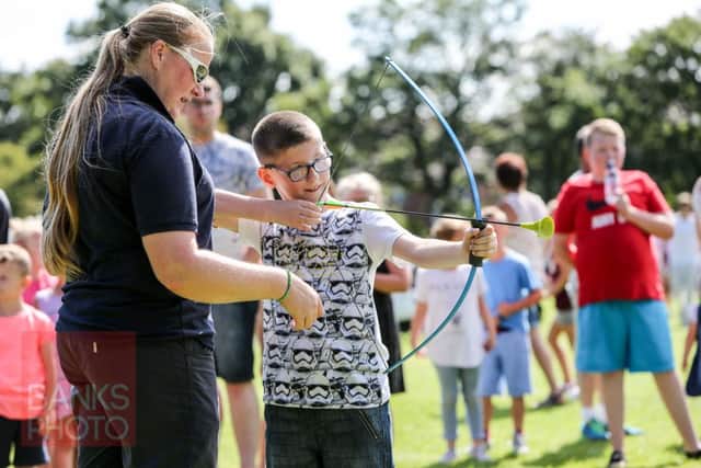 Richard Swales tries archery with Claire Blanchard at a family funday in Rossmere Park, Hartlepool. Picture: TOM BANKS