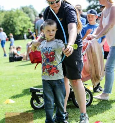 Mckenzie Hall tries archery with Claire Blanchard at a family funday in Rossmere Park, Hartlepool. Picture: TOM BANKS