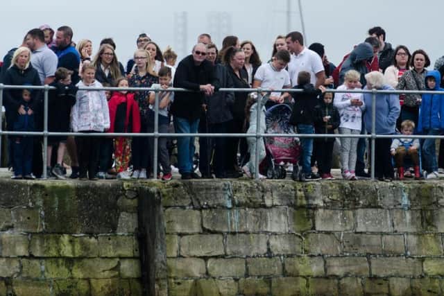Crowds line the harbour wall