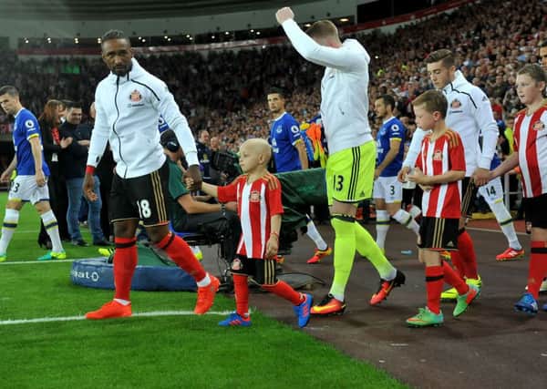 Bradley Lowery walks out with Sunderland captain Jermain Defoe.