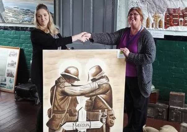 Kay King presents the painting to museum manager Diane Stephens.