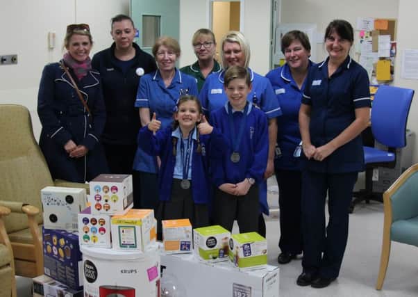 Tanya (far left) with Flynn and Isla, Selina from Tesco, second left, and staff in the chemotherapy unit.