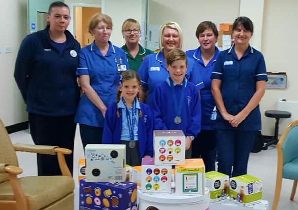 Flynn and Isla Beach hand over items to the chemotherapy unit at University Hospital of Hartlepool which they had raised money to buy.