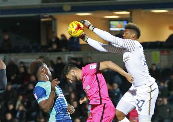 Wycombe keeper Jamal Blackman collects a cross from above Pools' Billy Paynter