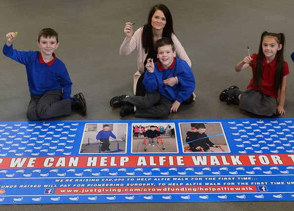 (left to right) Izzy Davies, Louis Weatherill-Smith, Alfie Smith and Mum Anne Marie Stalley with Amy Howlett and Alex Smith (brother of Alfie) signing the charity footprints poster at Throston Primary School. Picture by FRANK REID