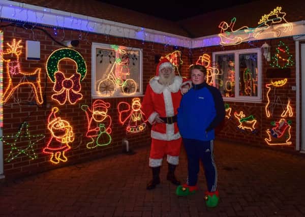 Jack Richardson with Santa Claus outside his house covered in Christmas lights, in  Park Lane Horden, last night