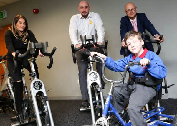 A cycle challenge in aid of Alfie Smith will be taking place in Middleton Grange, Hartlepool.  The bikes are being supplied by Xercise4less in Hartlepool. Pictured are Dani Ashworth and Darren Wilson from Xercise4less and centre manager Mark Rycraft with Alfie Smith. Picture: TOM BANKS