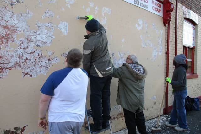 249 Artrium members Gavin Cummings, artists Mr Eyes, Artrium member Terry Alexander and Neville Hill prepare the old wall for paining