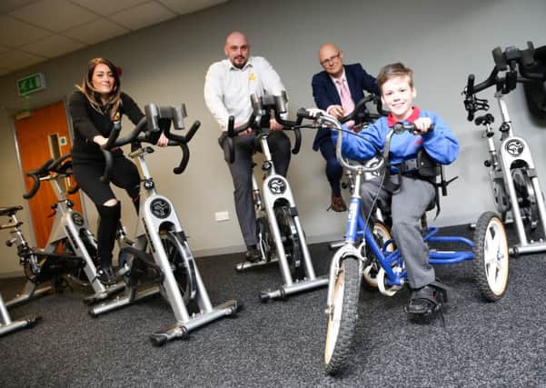 A cycle challenge in aid of Alfie Smith will be taking place in Middleton Grange, Hartlepool.  The bikes are being supplied by Xercise4less in Hartlepool. Pictured are Dani Ashworth and Darren Wilson from Xercise4less and centre manager Mark Rycraft with Alfie Smith. Picture: TOM BANKS