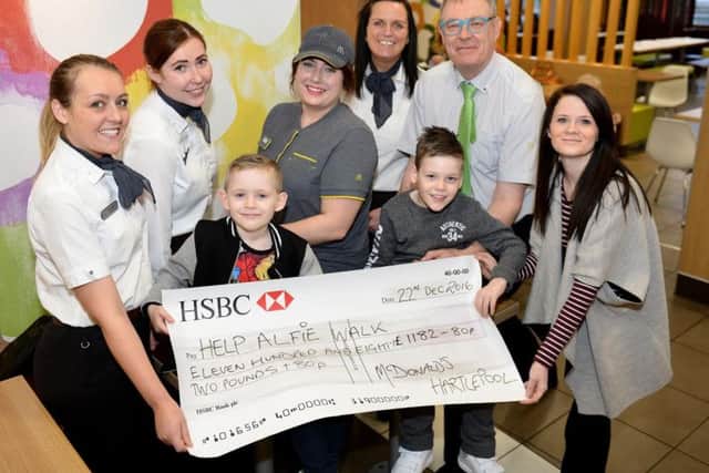 Alfie Smith (front middle) is presented with a cheque for Â£1182.80 by (rear left to right) Alex Shaw (shift manager), Kym Thompson 1st assistant manager), Hannah Bradley (crew member), Bev Williamson (operations consultant and Jasper Maudsley (franchisee). along with his brother Alex and mum Annie Stalley. Picture by FRANK REID