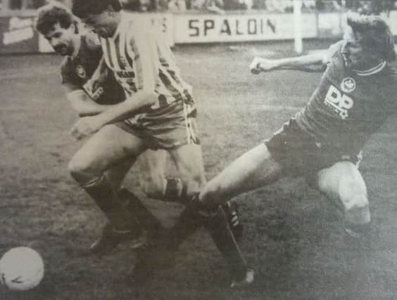 John McGinley evades a tackle from Swansea veteran Tommy Hutchinson.