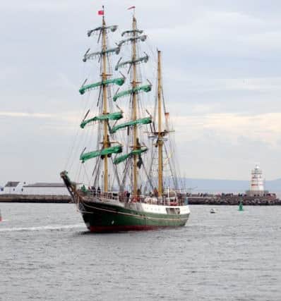 A tall ship arrives in port.