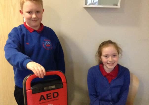 Pupils Ryan Williams and Evie Banks with the defibrillator.