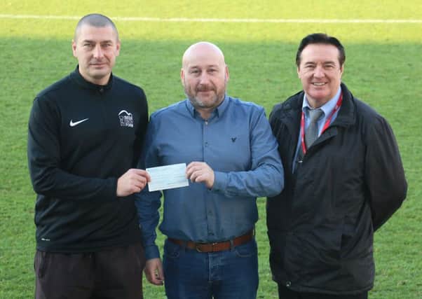 SRC sports centre manager Dave Morgan and SRC Bede Sixth Form director Rick Wells hand over a cheque to Hartlepool United operations director Mark Burrows on behalf of Prostate Cancer UK.