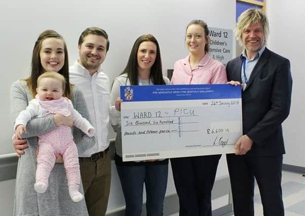 Laura and Patrick Boyd and baby Harper present their cheque to the RVI.