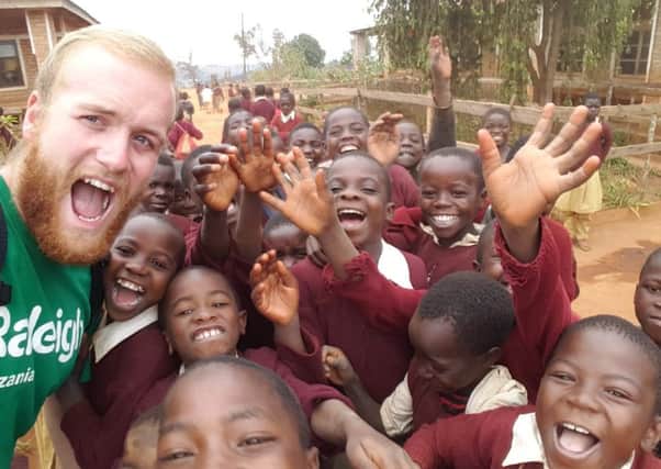Adrian poses for a photograph with the children of Tanzania.