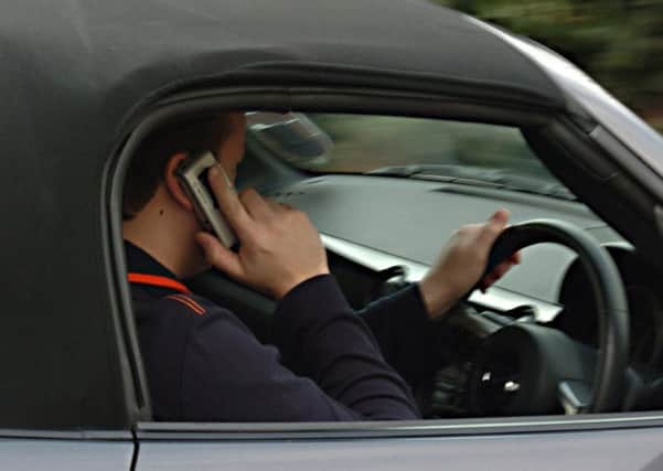 A man using his mobile phone while driving.