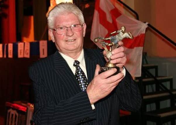 Kenny Johnson proudly holds a trophy aloft.