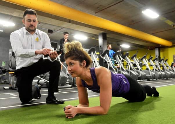 Karl Brown (sales and marketing manager) times Chelsea McKie planking as she trains to take part in the Anthony Nolan charity event being held in Xercise4Less. Picture by FRANK REID
