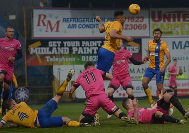 Mansfield's Rhys Bennett clears with a header as Pools try to attack