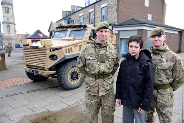 Nathan Chawner (14) photographed in front of the Foxhound Armoured Personal Carrier with privates (left to right) Liam Davenport and Aiden Batemen as he visited Army display in Church Square, Hartlepool. Picture by FRANK REID
