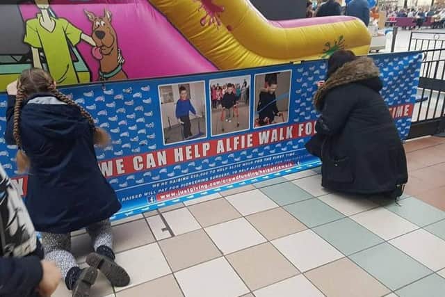 Shoppers sign a footprint in aid of Alfie