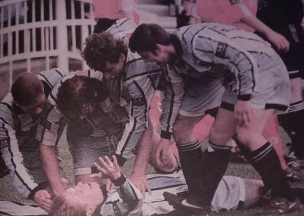 Team mates help Russell Bradley to celebrate his goal.