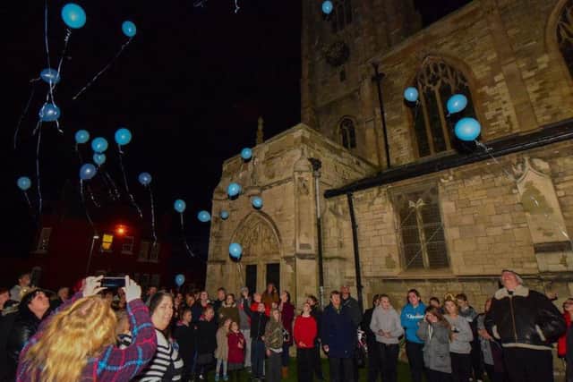 Blue balloons are released by the Dyke House community.