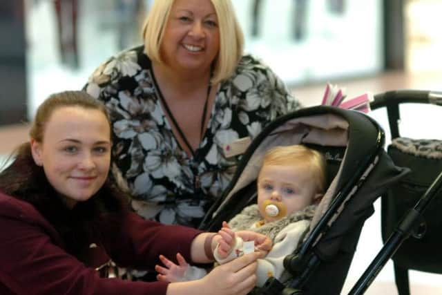Middleton Grange Shopping Centre Retail executive Suzanne Chaney with mum Helena Davies who is shown placing one of  the wristbands on 18 month old daughter Leila.