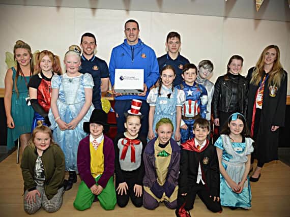 Sunderland AFC players (centre from left) George Honeyman, John O'Shea and Donald Love with primary school youngsters and Foundation staff